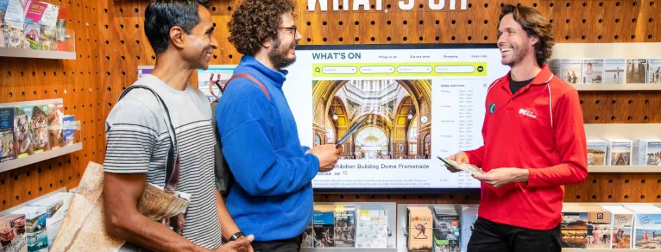 Tourists being shown brochures by staff in Visitor Hub